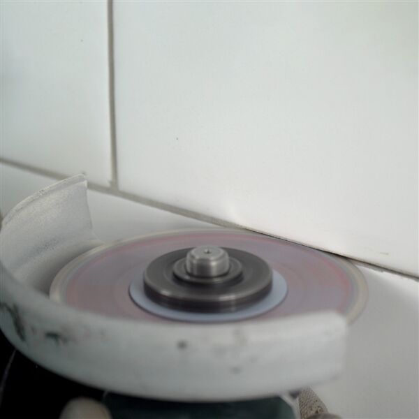 11115421006-7T Professional tile installer using Distar Cleaner blade for grout removal