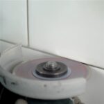 Professional tile installer using Distar Cleaner blade for grout removal
